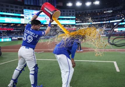 Toronto Blue Jays catcher Brandon Valenzuela (59) pours the water bucket on right fielder Jesus Sanchez (12) against the Miami Marlins at the end of the ninth inning at the Rogers Centre.