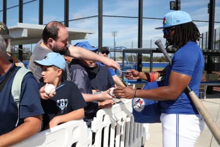 Toronto Blue Jays infielder Charles McAdoo (26) signs autographs during spring training practices.