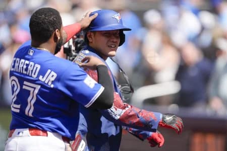 Toronto Blue Jays first baseman Vladimir Guerrero Jr. (27) puts the home run jacket onto Toronto Blue Jays third baseman Kazuma Okamoto (7) after his solo home run against the Miami Marlins during the sixth inning at Rogers Centre.