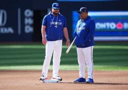 Toronto Blue Jays manager John Schneider (14) talks with associate manager DeMarlo Hale (15) during batting practice before a game against the Miami Marlins at the Rogers Centre.