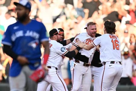 Teammates surround Baltimore Orioles infielder Pete Alonso (25) after Alonso hit a walk-off single in the ninth inning against the Toronto Blue Jays at Oriole Park at Camden Yards.