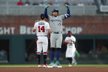 Toronto Blue Jays designated hitter George Springer (4) reacts after hitting a double against the Atlanta Braves in the first inning at Truist Park.