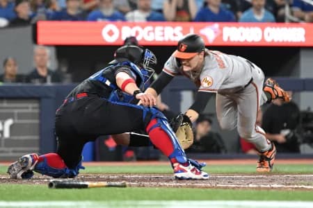 Baltimore Orioles shortstop Gunnar Henderson (2) dives into home plate to score a run ahead of the tag from Toronto Blue Jays catcher Brandon Valenzuela (59) in the sixth inning at Rogers Centre.