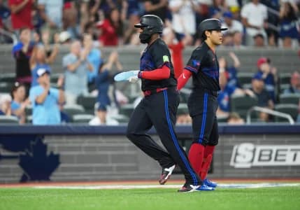 Toronto Blue Jays first baseman Vladimir Guerrero Jr. (27) scores a run and celebrates with third baseman Kazuma Okamoto (7) against the New York Yankees during the fifth inning at Rogers Centre.