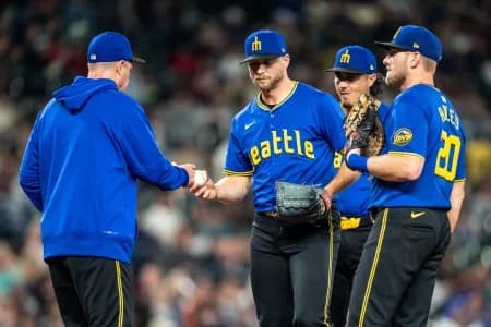 Seattle Mariners relief pitcher Austin Voth (30), second from left, is pulled by manager Dan Wilson, left, during a meeting at the mound with third baseman Josh Rojas (4), second from right, and first baseman Luke Raley (20) in the seventh inning against the Texas Rangers at T-Mobile Park.