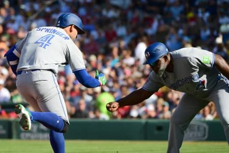 Toronto Blue Jays designated hitter George Springer (4) reacts with third base coach Carlos Febles (51) after hitting a three run home run during the third inning against the Boston Red Sox at Fenway Park.