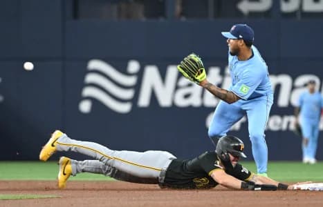 Pittsburgh Pirates first baseman Spencer Horwitz (2) dives back to second base as Toronto Blue Jays second baseman Lenyn Sosa (50) waits for the throw in the second inning at Rogers Centre.
