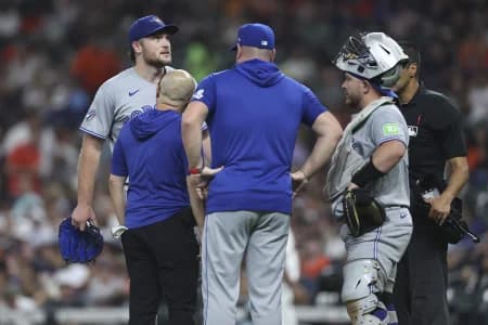Toronto Blue Jays starting pitcher Trey Yesavage (39) is evaluated by a trainer after an apparent injury during the third inning against the Houston Astros at Daikin Park.