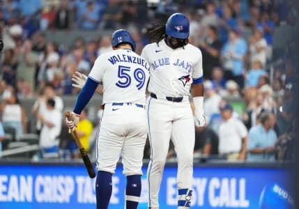 Toronto Blue Jays third baseman Charles McAdoo (26) hits a home run and celebrates with catcher Brandon Valenzuela (59) during the fifth inning against the Boston Red Sox at Rogers Centre.
