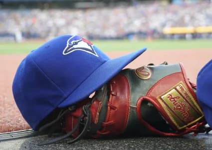 A Toronto Blue Jays hat and glove outside of the dugout during a game against the Texas Rangers at Rogers Centre