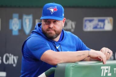 Toronto Blue Jays manager John Schneider (14) looks out from the dugout against the Kansas City Royals prior to a game at Kauffman Stadium