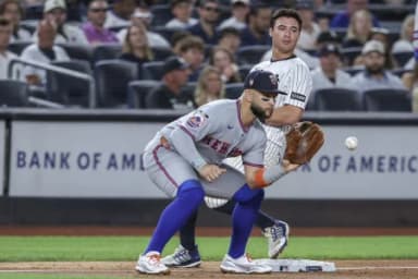 New York Yankees second baseman Anthony Volpe (11) beats the throw to New York Mets third baseman Bo Bichette (19) in the second inning at Yankee Stadium.