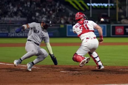 New York Yankees shortstop Jose Caballero (72) slides into home plate to beat a throw to Los Angeles Angels catcher Tyler Heineman (31) to score in the 10th inning at Angel Stadium
