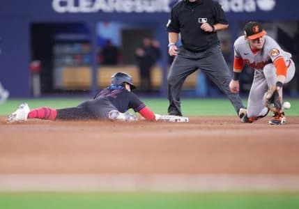 Toronto Blue Jays second baseman Ernie Clement (22) slides into second base with a double ahead of the tag from Baltimore Orioles shortstop Gunnar Henderson (2) during the ninth inning at Rogers Centre.