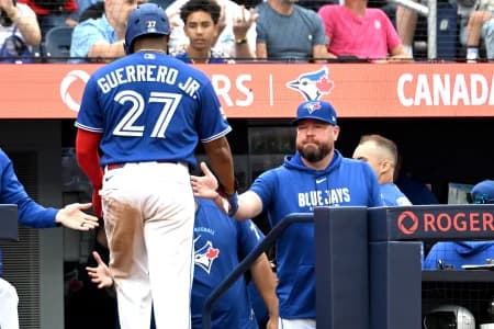 Toronto Blue Jays manager John Schneider (14) greets first baseman Vladimir Guerrero Jr. (27) after he scored a run against the Baltimore Orioles in the seventh inning at Rogers Centre.