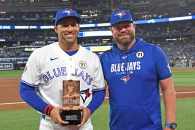 Toronto Blue Jays designated hitter George Springer (4) receives the team Roberto Clemente award from manager John Schneider (14) before play against the Detroit Tigers at Rogers Centre.