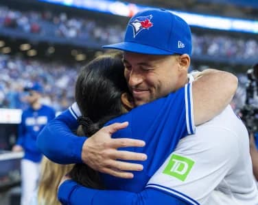 Toronto Blue Jays designated hitter George Springer (4) hugs his mother after defeating the Cincinnati Reds and calling it a career at Rogers Centre