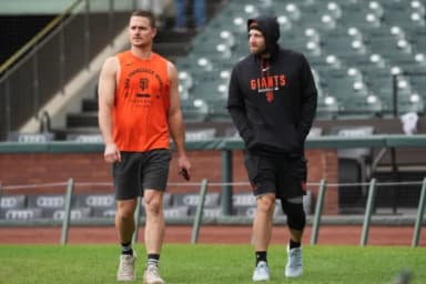 San Francisco Giants third baseman Matt Chapman (left) and second baseman Casey Schmitt (right) walk on the field before the game against the Colorado Rockies at Oracle Park.