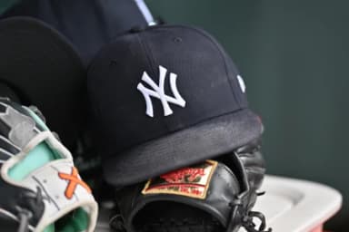 A detail view of a New York Yankees baseball hat and a glove during the eighth inning against the Chicago Cubs at Wrigley Field