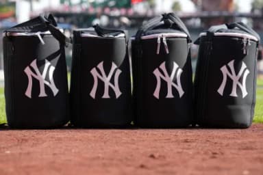 Equipment bags with the New York Yankees logo sit on the field before the game against the San Francisco Giants at Oracle Park.