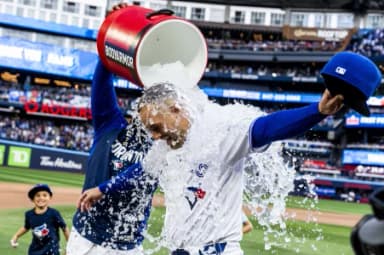 Toronto Blue Jays designated hitter George Springer (4) gets water dumped on him by first baseman Vladimir Guerrero Jr. (27) and his children after defeating the Cincinnati Reds at Rogers Centre.